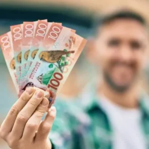 Happy customer holding cash after selling car in Christchurch.